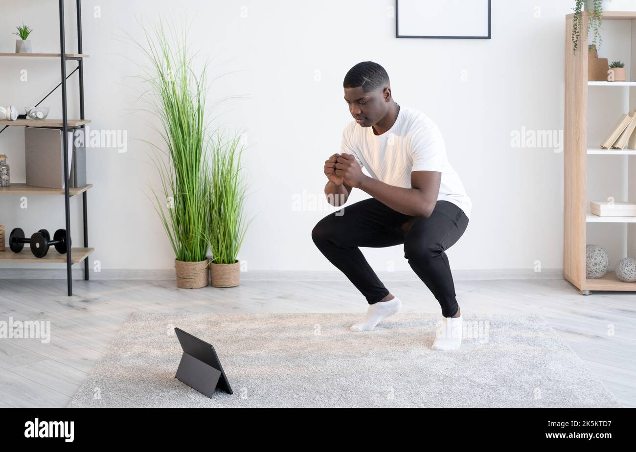 entrenamiento en casa negro hombre gimnasio en línea Foto de stock