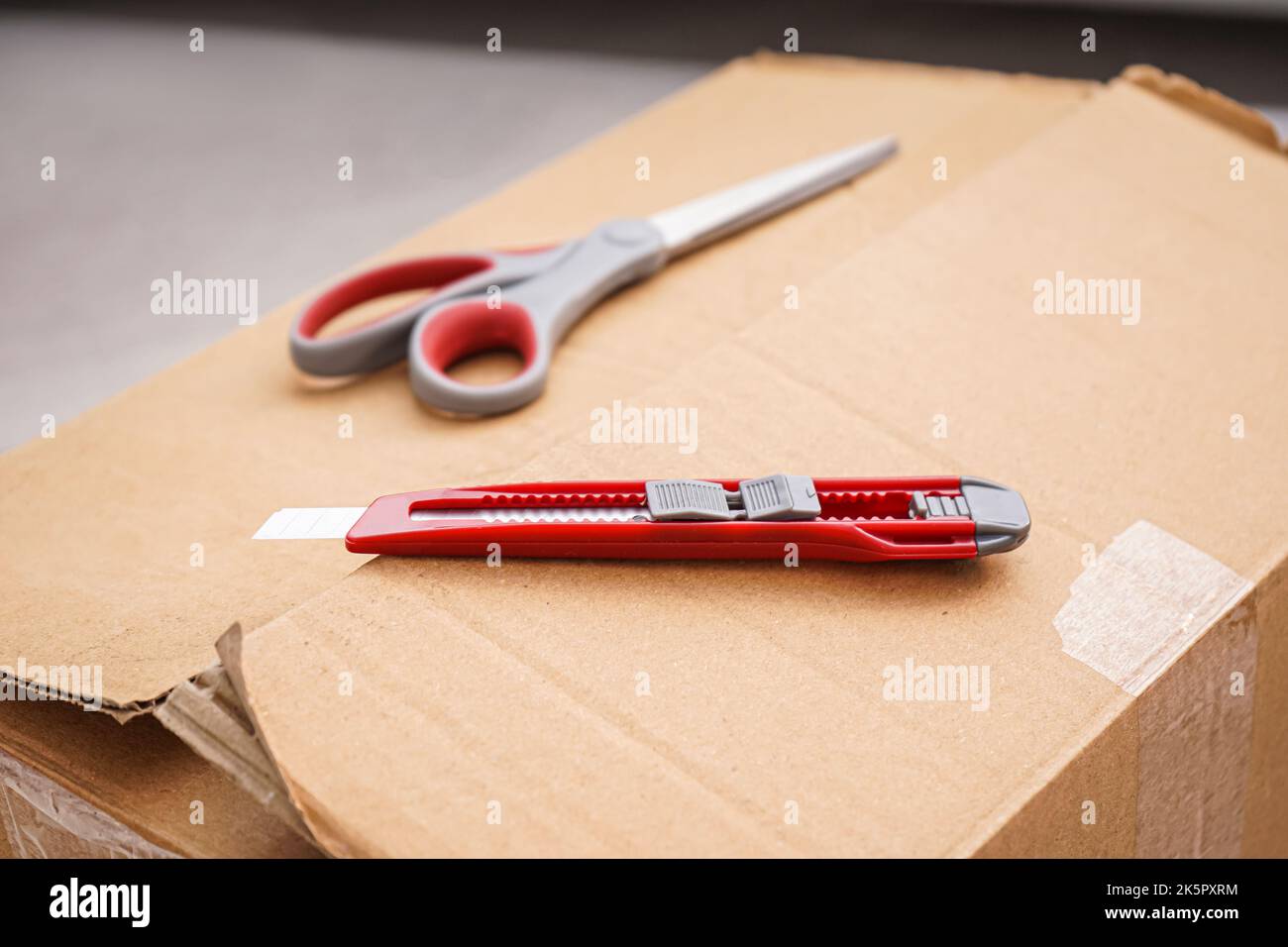 Cuchillo de uso general con tijeras en caja de cartón, primer plano  Fotografía de stock - Alamy