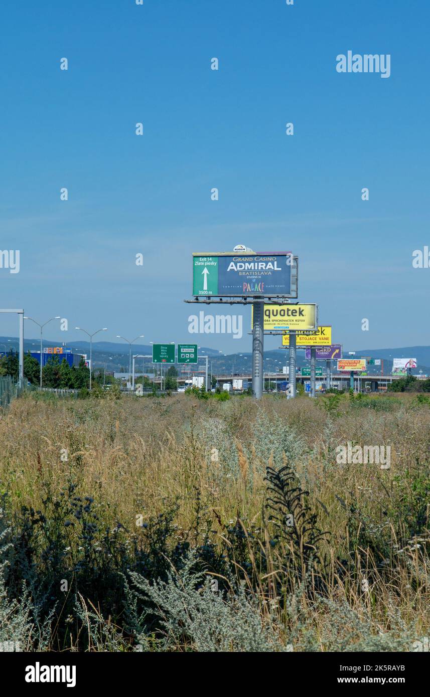 Bratislava, Eslovaquia - 4 de agosto de 2022: La contaminación visual espacial. Publicidad al aire libre excesiva y vallas publicitarias que bordean la carretera en Bratisla Foto de stock