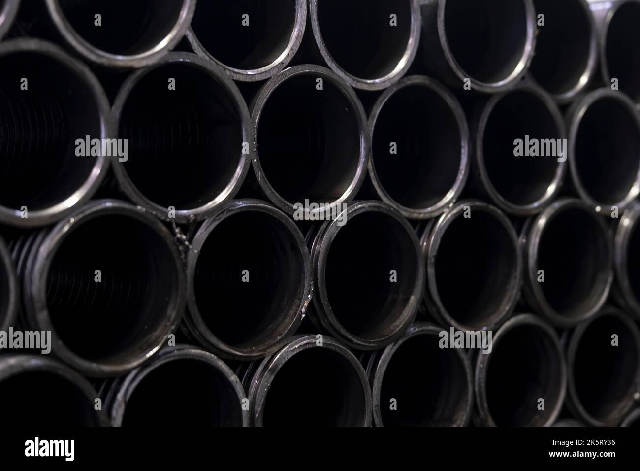 materiales de perfil de acero utilizados en la industria. tuberías de hierro apiladas. Tubo central de enfoque selectivo Foto de stock