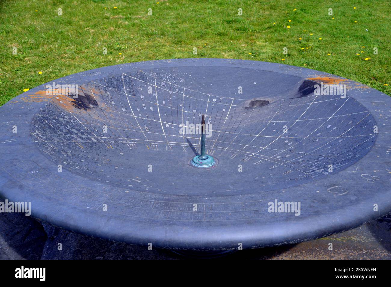 Big Blue Slate Sundial (muestra aproximadamente 10,15am) en The Edge of the Wildflower Meadow en Holker Hall & Gardens, Lake District, Cumbria, Inglaterra, Reino Unido. Foto de stock