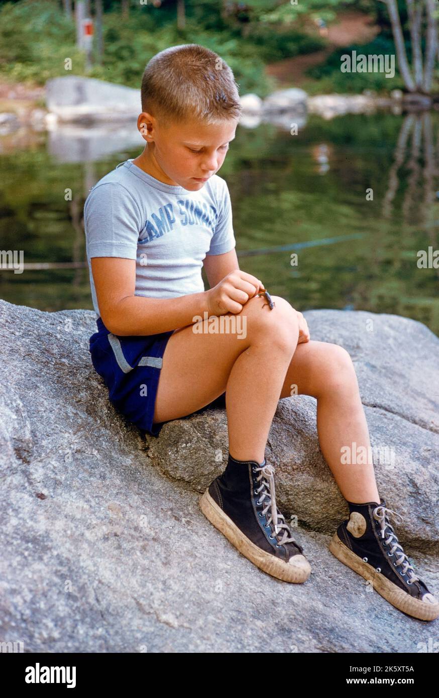 Joven con lagarto pequeño en la rodilla en el campamento de verano, Camp Sunapee, New Hampshire, EE.UU., Toni Frissell Collection, Julio 1955 Foto de stock