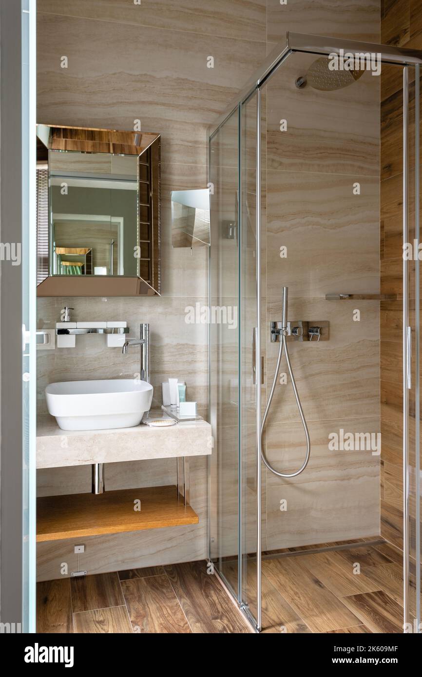 Moderno y elegante cuarto de baño con cabina de ducha de cristal en una  nueva casa de lujo. Amplio y luminoso cuarto de baño interior moderno con  paredes claras y marrones, ducha