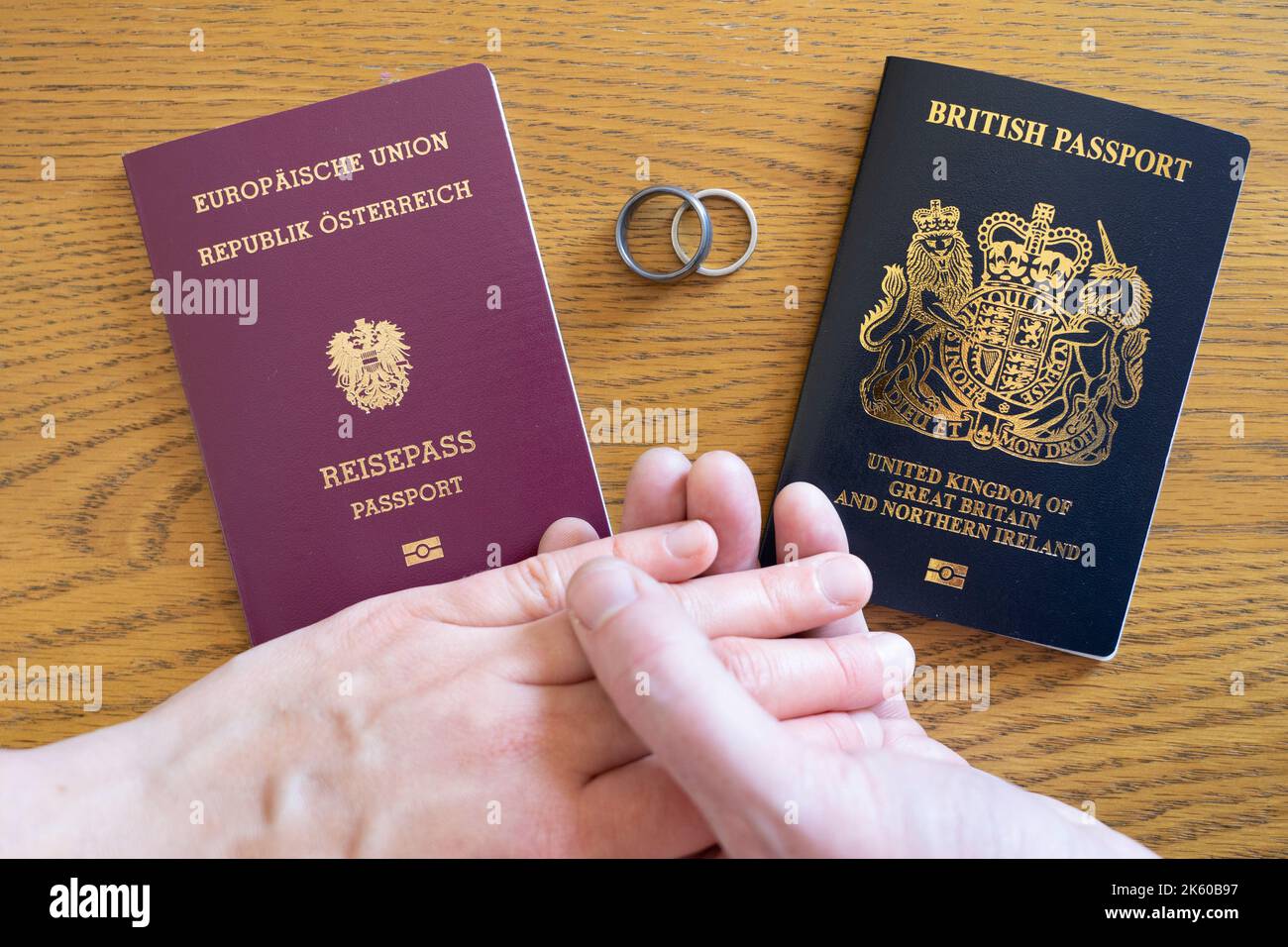 El Brexit afecta el estatus migratorio de los cónyuges y parejas de ciudadanos británicos en la UE. Pasaportes de la UE y del Reino Unido, anillos y una pareja casada de manos Foto de stock