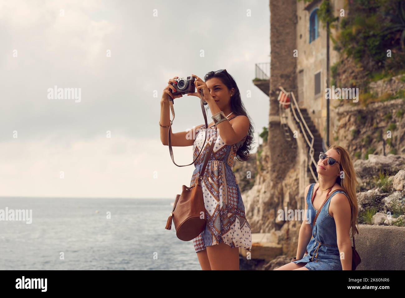 Captar la belleza italiana. Una atractiva mujer joven que se vincula con su amiga en Italia y utiliza una cámara. Foto de stock