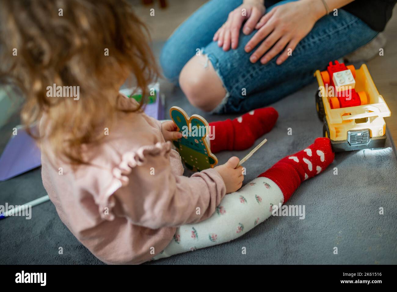 Retrato del bebé lindo que juega con los juguetes coloridos en casa  mientras se encuentra en su estómago. Parque infantil para bebés Fotografía  de stock - Alamy