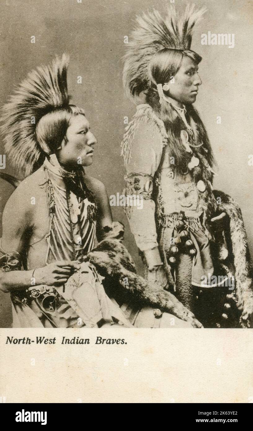 Una magnífica fotografía de dos guerreros de la Primera Nación de una tribu indígena de los territorios del noroeste - Canadá. Circa 1900s Foto de stock