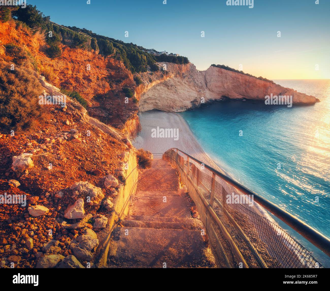Hermosas escaleras en la playa de arena al atardecer. Porto Katsiki, Grecia Foto de stock
