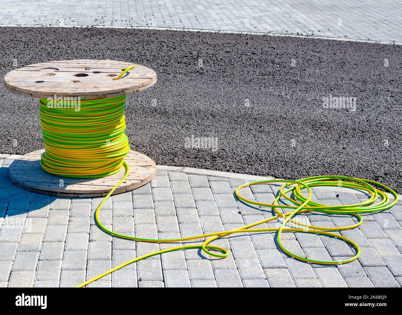 Cable cable eléctrico con bobina de madera de cable eléctrico a la espera de ser deslizado hacia el conducto Foto de stock