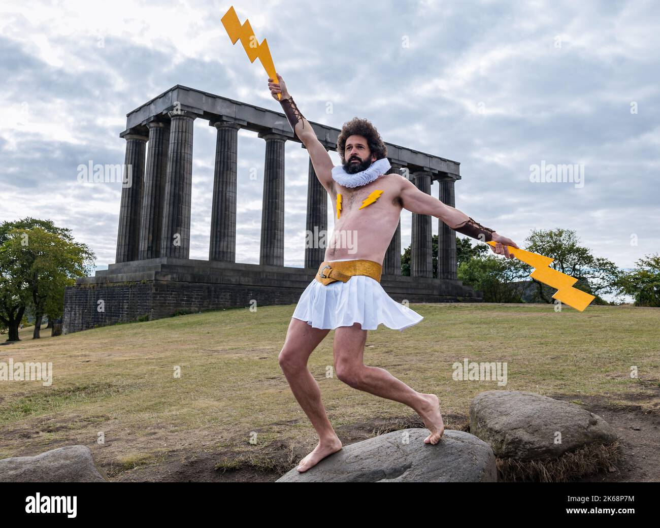 Fringe Garry Starr alias Damien Warren-Smith como dios griego Zeus con relámpagos, Calton Hill, Edimburgo, Escocia, Reino Unido Foto de stock