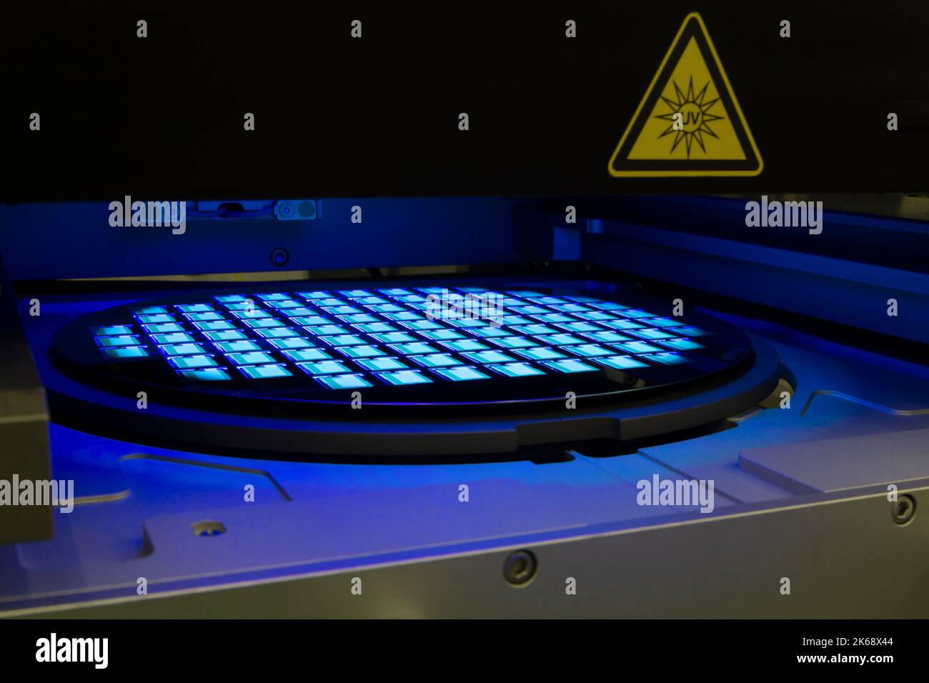 Oblea de silicio con chips de lightinhg en luz de neón. Semiconductores. Foto de stock