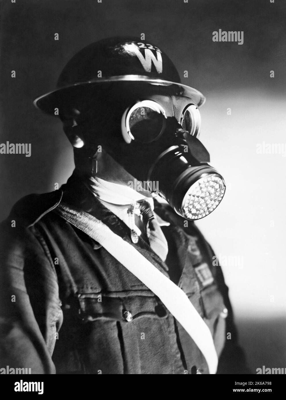 Retrato de un alcaide de ataque aéreo con casco de acero y máscara de gas, alrededor de 1940. Foto de stock