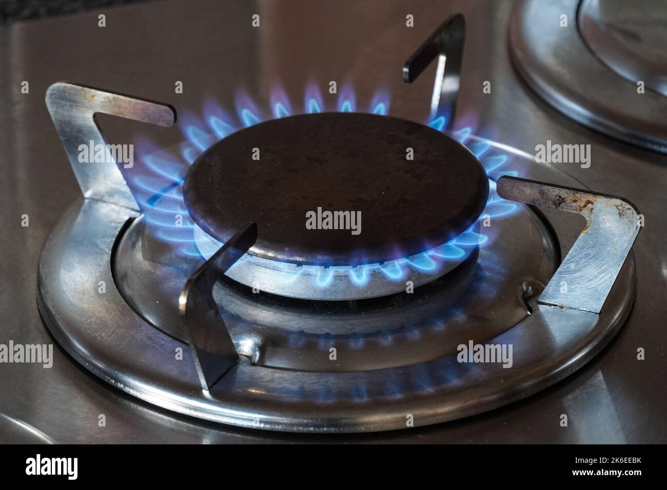 Una imagen bien enfocada que captura las intensas llamas azules de un  quemador de estufa de gas propano en una cocina hogareña