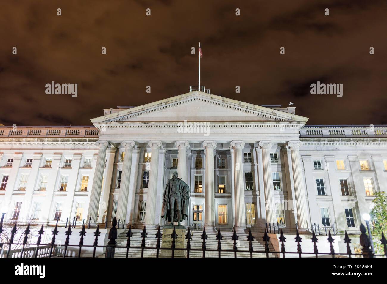 La entrada norte de los EE.UU. Edificio del Departamento del Tesoro y la estatua de Albert Gallatin en el centro de Washington, D.C., vista en una noche de invierno. Foto de stock