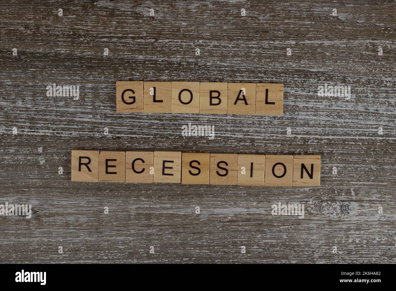 Recesión global deletreada en letras de madera en un fondo de madera, palabras financieras de madera tipografía concepto de letras Foto de stock