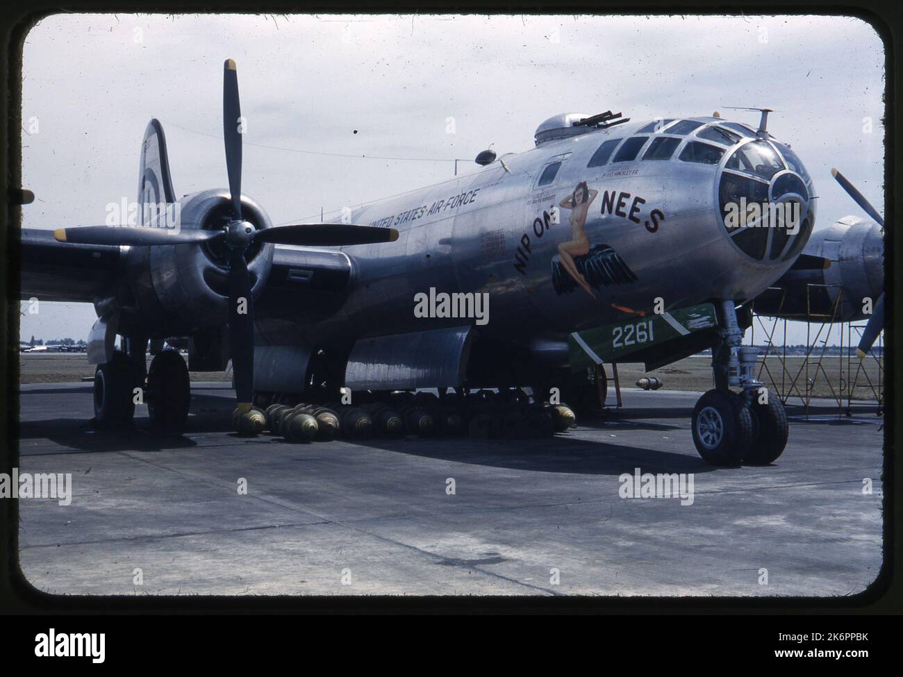 Vista frontal derecha de tres cuartos del Boeing B-29 Superfortress con bombas debajo del avión. El arte de la nariz incluye el apodo con el dibujo, ' Nip en Nees.'. Vista frontal derecha de tres cuartos del Boeing B-29 Superfortress con bombas debajo del avión. El arte de la nariz incluye el apodo con el dibujo, ' Nip en Nees.'. Foto de stock