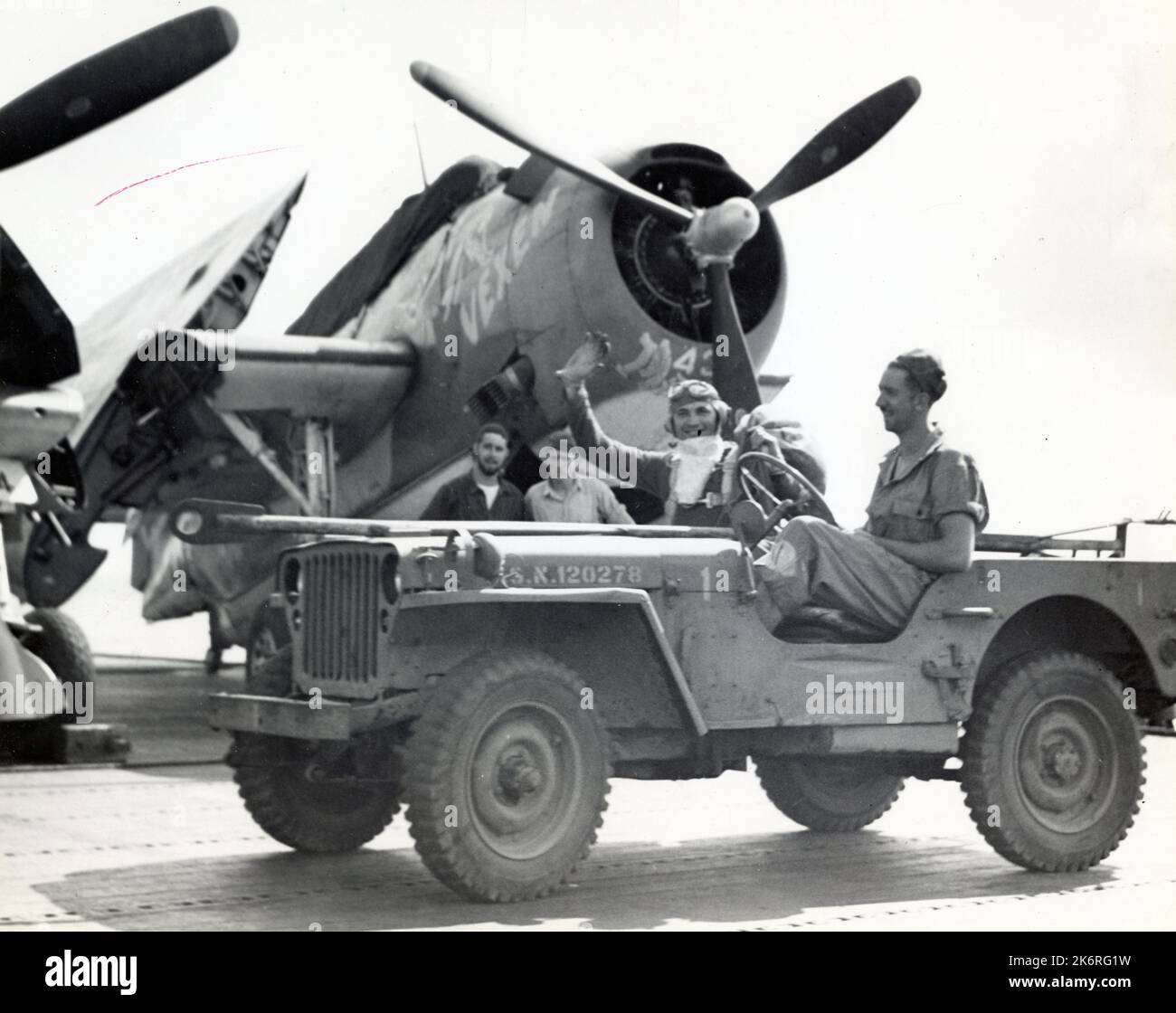 Fotografía de Santa Claus en el USS Enterprise (CV-6) “El día de Navidad, Santa Claus llega a bordo del USS Enterprise (CV-6) en un bombardero de buceo con seis aviones torpederos que llevan nombres de sus novillos, para distribuir regalos. El Teniente Louis L. Bangs (Air Group 10) juega el papel. “Vexen” en segundo plano.”. Foto de stock