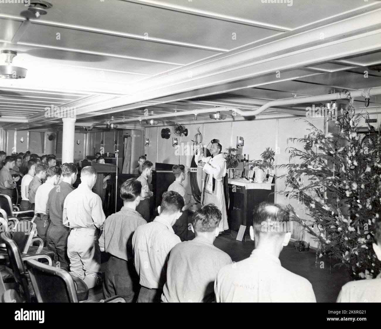 Fotografía que muestra el Servicio Divino en el USS Enterprise (CV-6) el día de Navidad“Servicio Divino en el USS Enterprise (CV-6) el día de Navidad. Misa Católica de Medianoche: El capellán es el Reverendo Felix Reitlingshofer, Teniente, un fraile franciscano”. Foto de stock