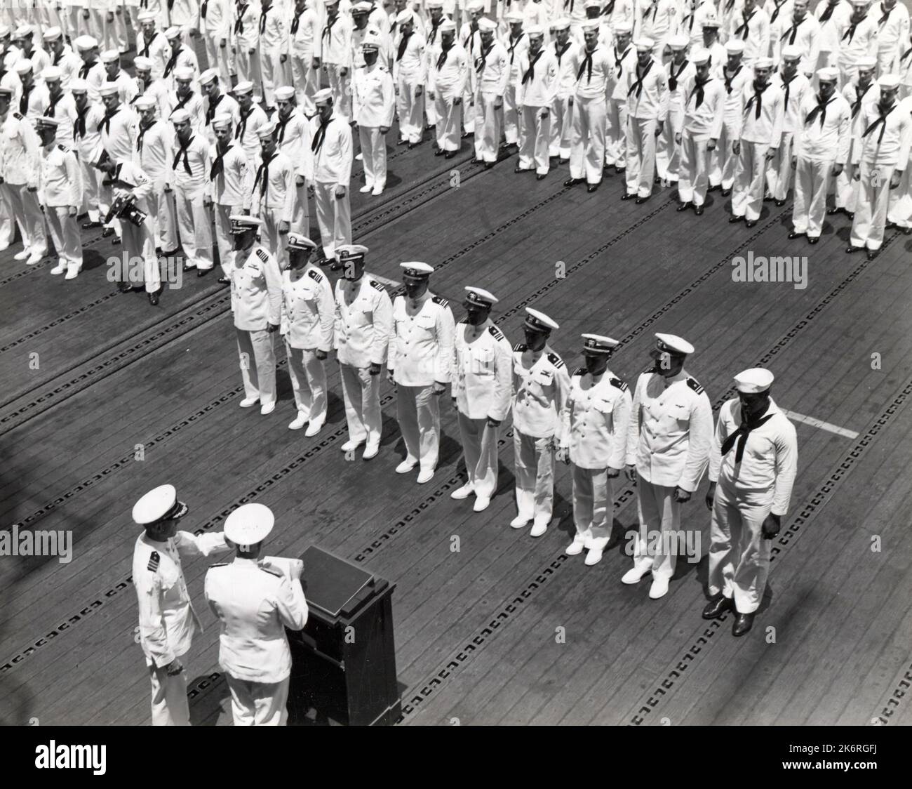 Oficiales Navales y Hombres Enlistados Esperan Presentación de Oficiales Heroísticos Individuales y Hombres Enlistados esperan la presentación de premios heroicos individuales por ADM. Cofre W. Nimitz en Pearl Harbor. La ceremonia tuvo lugar en la plataforma de vuelo del USS Enterprise (CV-6). Fotógrafo: USS Enterprise. Foto de stock