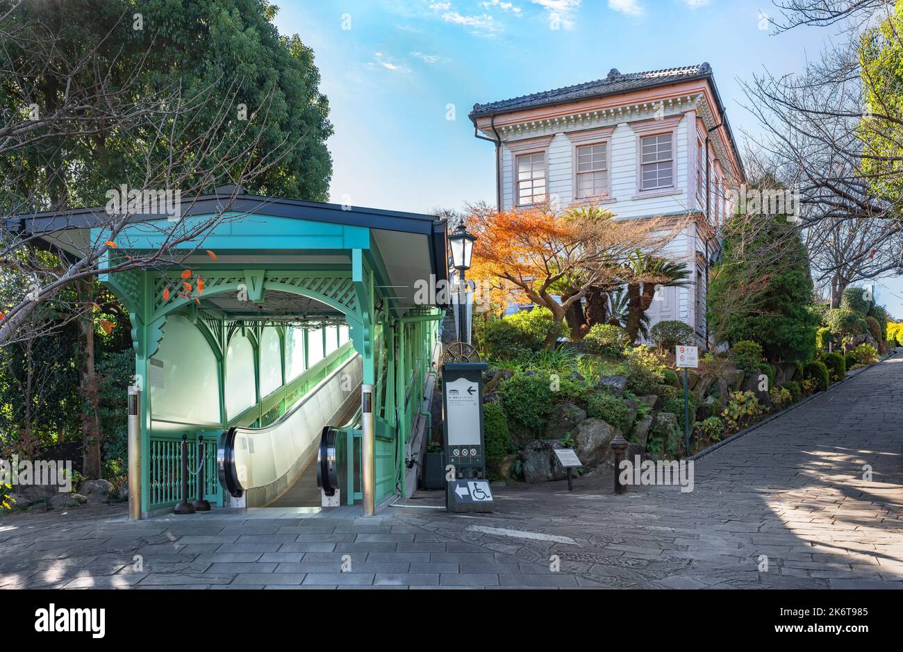 nagasaki, kyushu - diciembre de 13 2021: La escalera mecánica del jardín Glover cubierta por un techo retro arqueado de piedra al lado de la pendiente que conduce a la antigua M Foto de stock