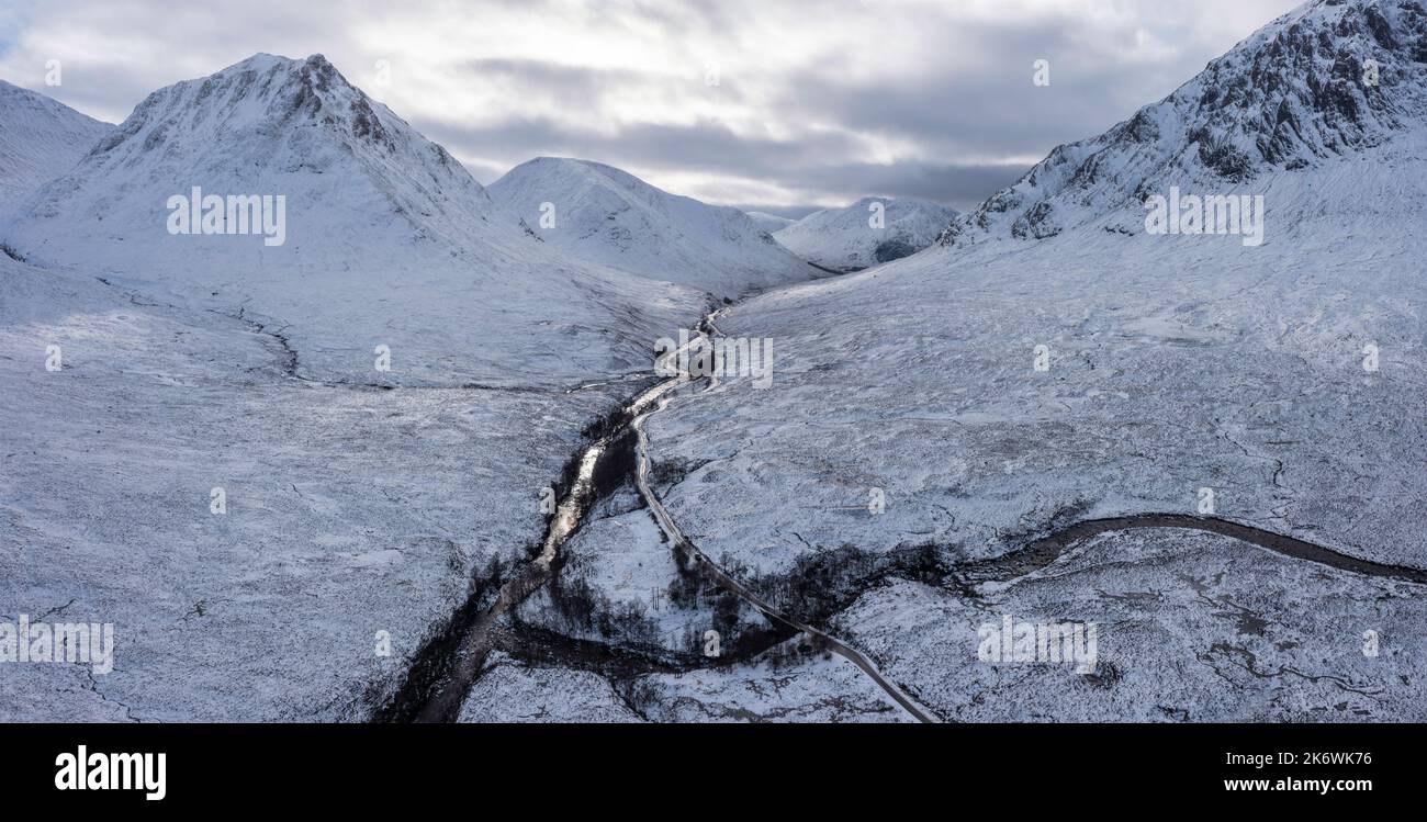 Impresionante imagen de paisaje aéreo de aviones teledirigidos de Stob Dearg y Glencoe en las Tierras Altas de Escocia durante las profundas nevadas y los hermosos cielos azules Foto de stock