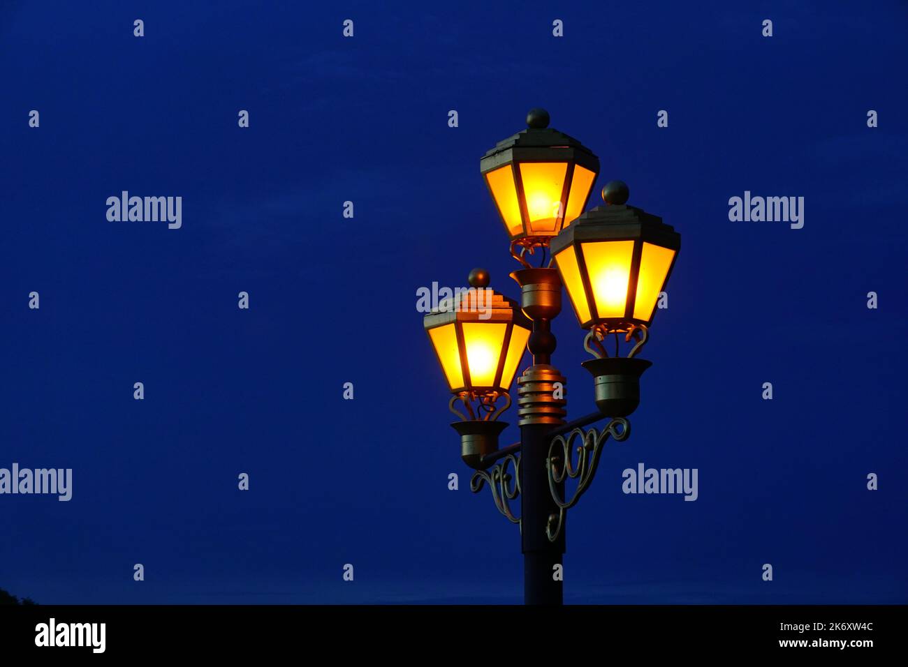 Lámparas antiguas Linterna de poste de luz que brilla en el cielo de la puesta de sol Foto de stock