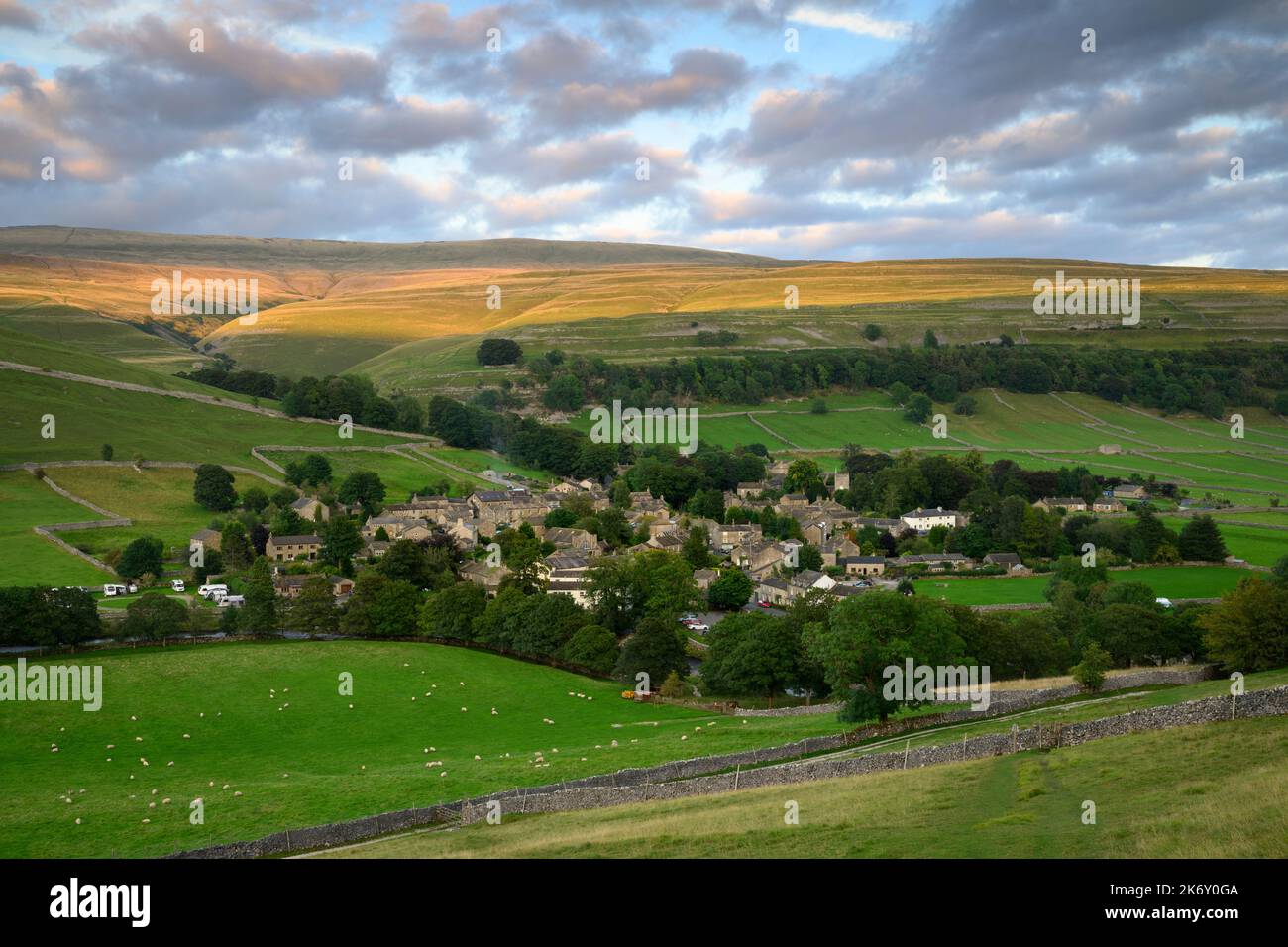 Pintoresco pueblo de Dales (casas y casas) enclavado en el valle (laderas empinadas y tierras altas de páramos iluminadas por el sol) - Kettlewell, Yorkshire Inglaterra Reino Unido. Foto de stock