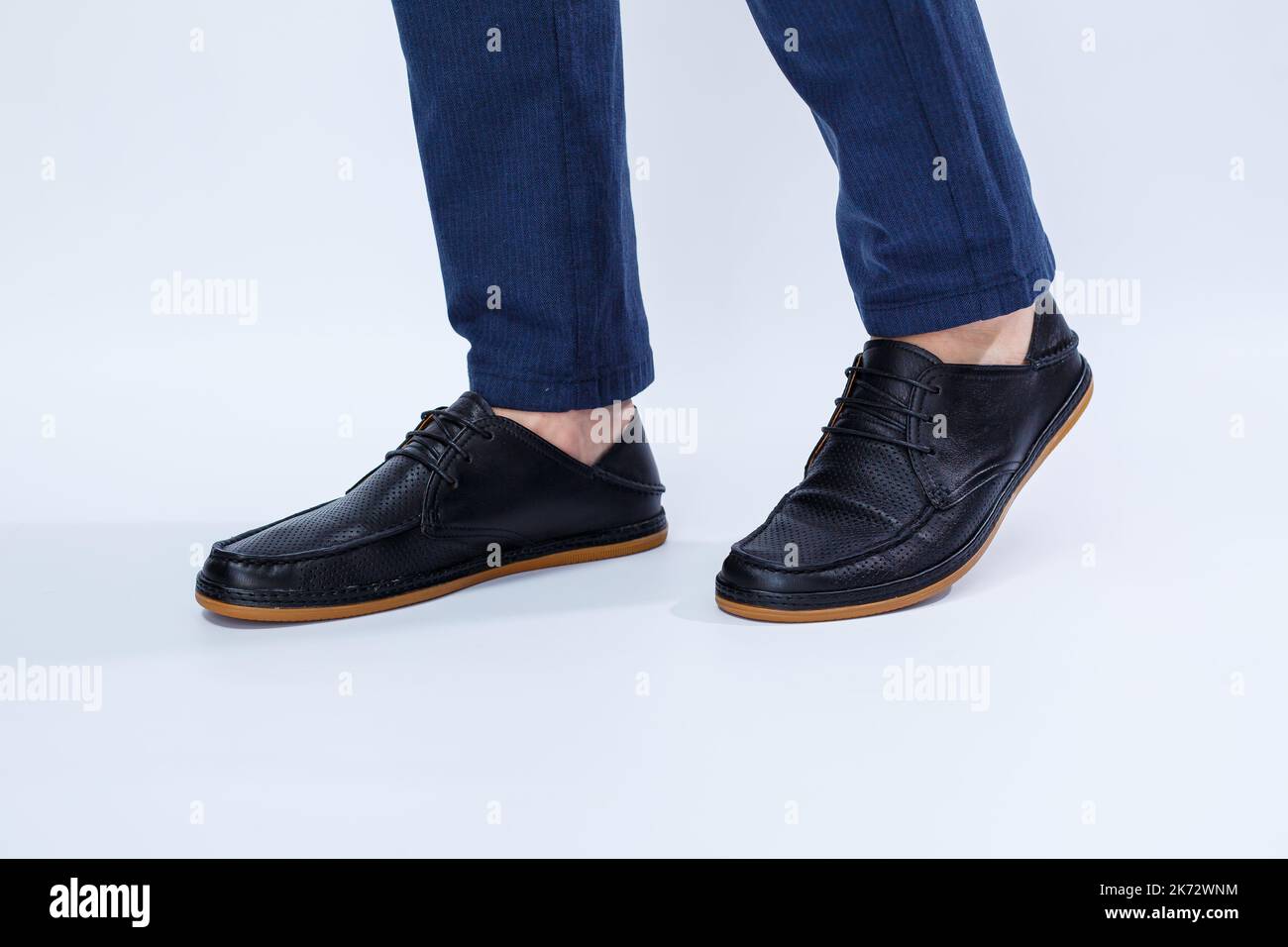 Un hombre lleva zapatos negros clásicos hechos de cuero natural con encaje,  zapatos para hombres con estilo de negocios. foto de alta calidad