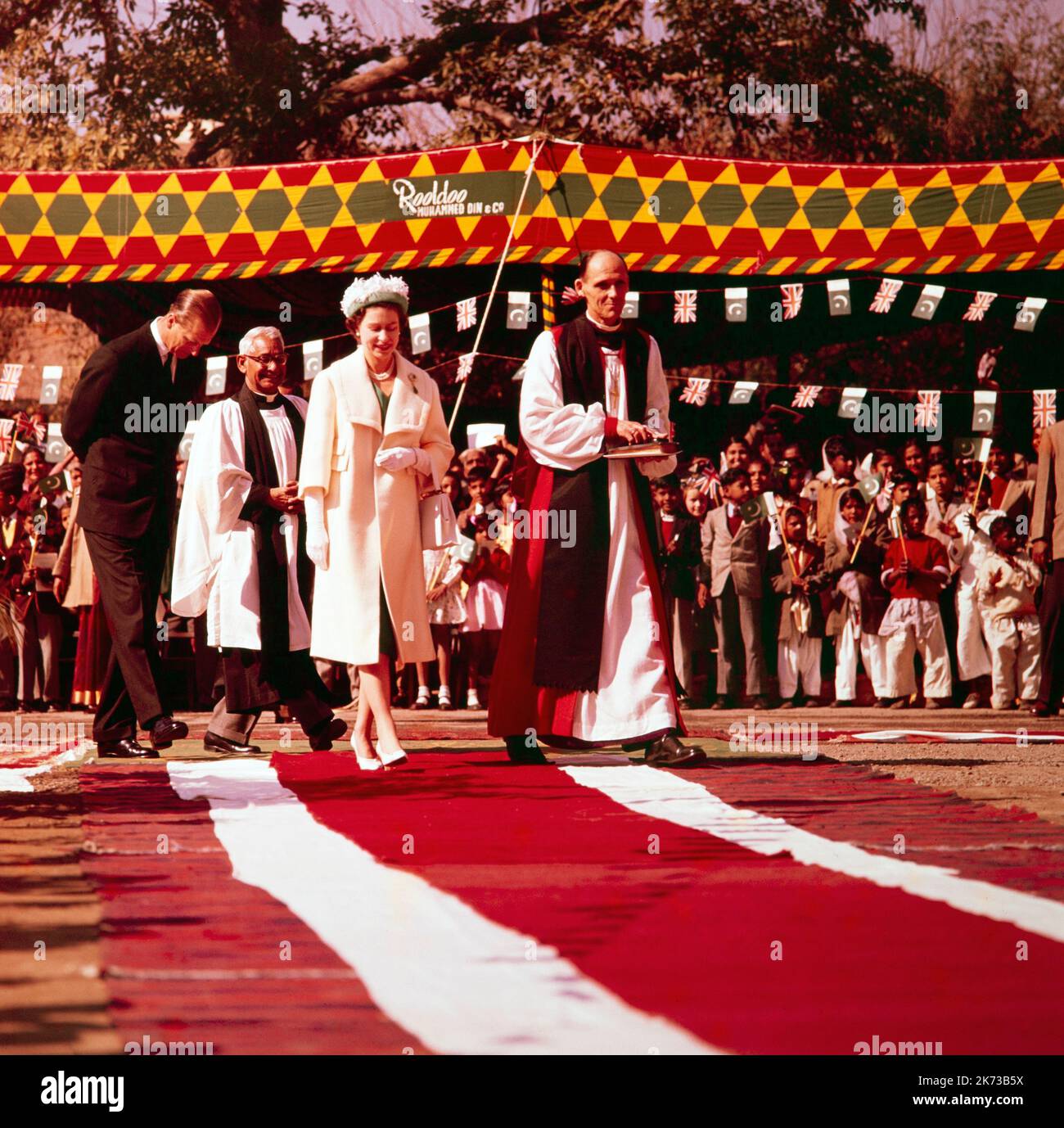 Fotografía en color de la época 1961 que muestra a la Reina Isabel II visitando la Catedral de Lahore en la India, con el Obispo de Lahore, el Reverendo L. A. Woolmer. Parte de la excursión india Queens 1961. El Príncipe Phillip en el fondo. Foto de stock