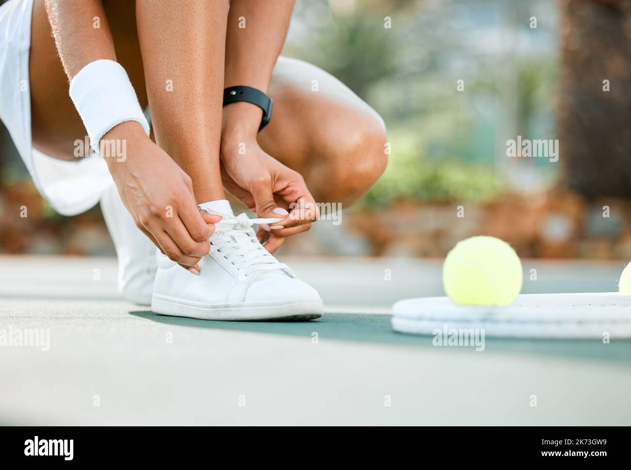 No tropezar en este campo. una joven y deportiva atándose los cordones  mientras juega al tenis en una pista Fotografía de stock - Alamy