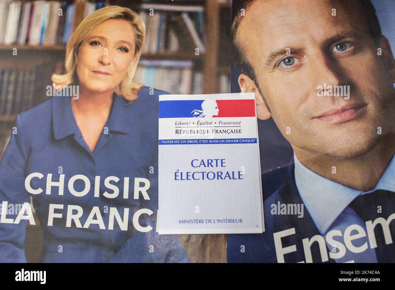 Ilustración, una tarjeta francesa de registro electoral se ve delante de los carteles oficiales de la campaña de los candidatos en las elecciones presidenciales francesas, la líder del partido político del Frente Nacional Francés (FN), Marine Le Pen y el presidente del movimiento político 'En Marche ! (En adelante !) Emmanuel Macron el 05 de mayo de 2017 en París, Francia. Foto de stock