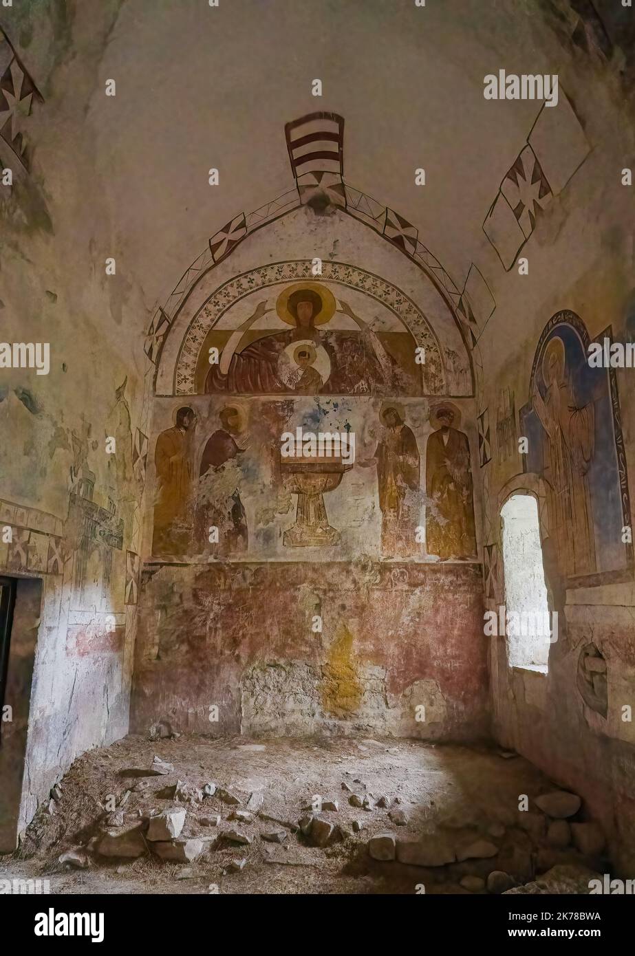 Murales y pinturas murales dentro de una antigua iglesia parcialmente arruinada en un pueblo medieval en España Foto de stock