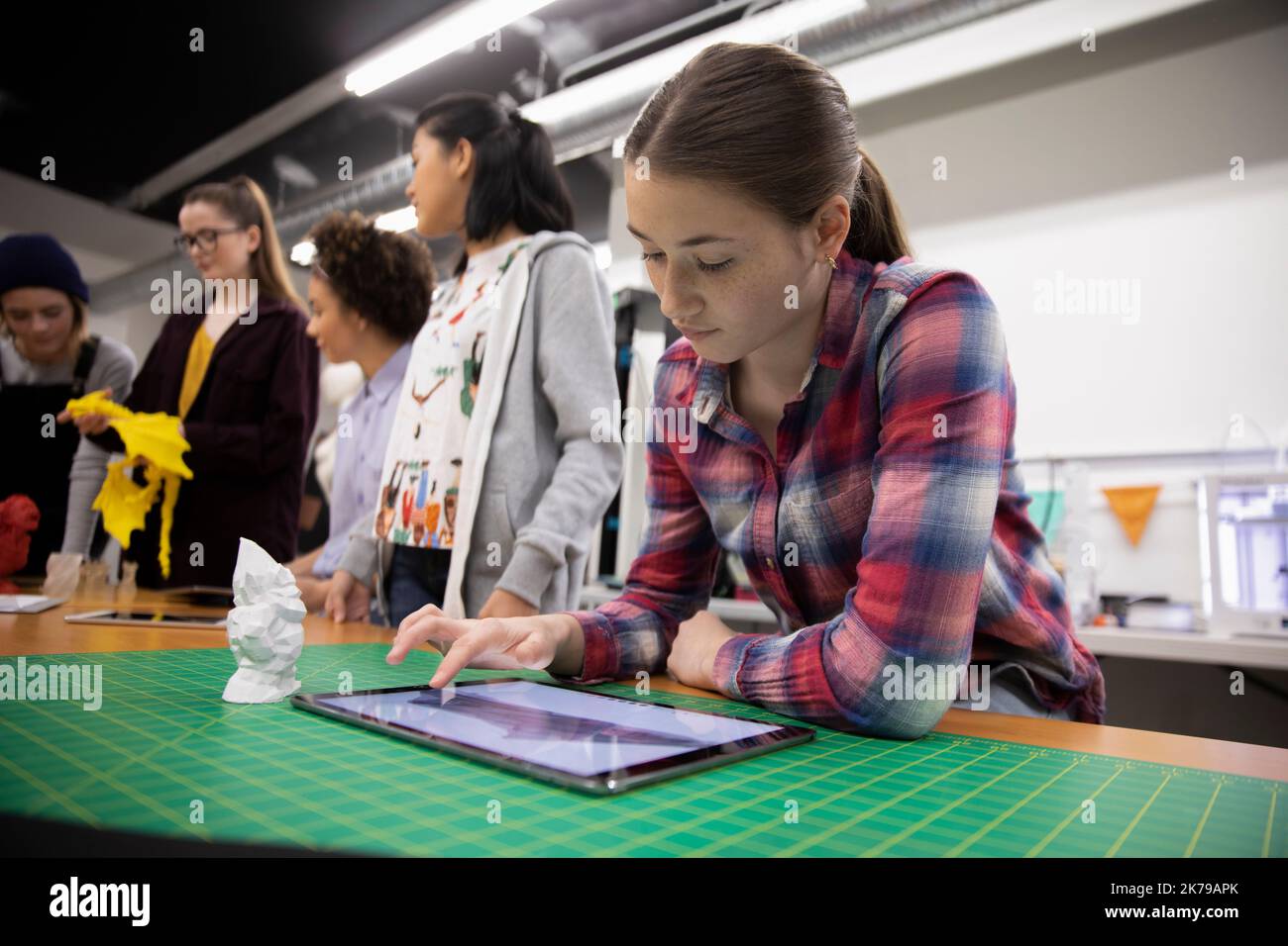 Estudiante que utiliza una tableta digital en un taller de impresión 3D Foto de stock