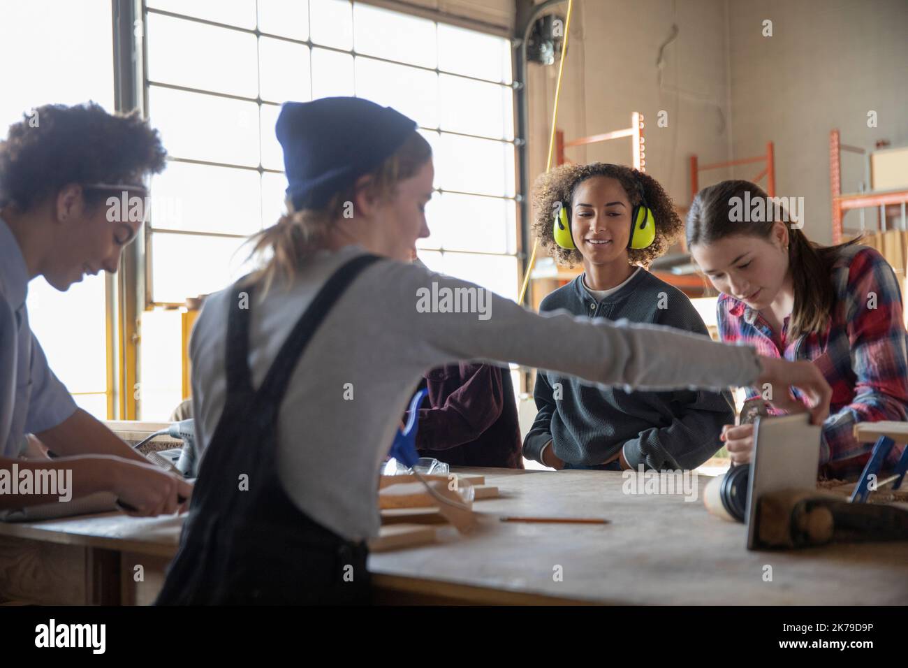 Alumnas que usan tabletas digitales en clase de carpintería Foto de stock