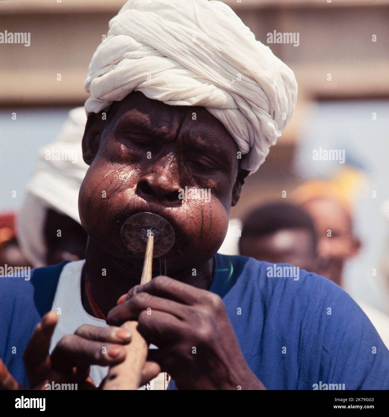 Una fotografía vintage en color 1960s tomada en Sudán mostrando el tradicional Charmer de Serpiente soplando en su encantadora pipa. Foto de stock