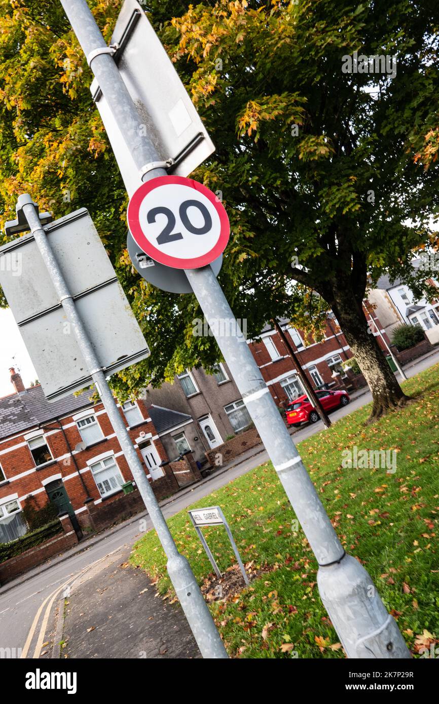 Vista detallada de un signo de límite de velocidad en carretera UK 20mph en una carretera bastante suburbana. Debido a la política del gobierno galés. Foto de stock