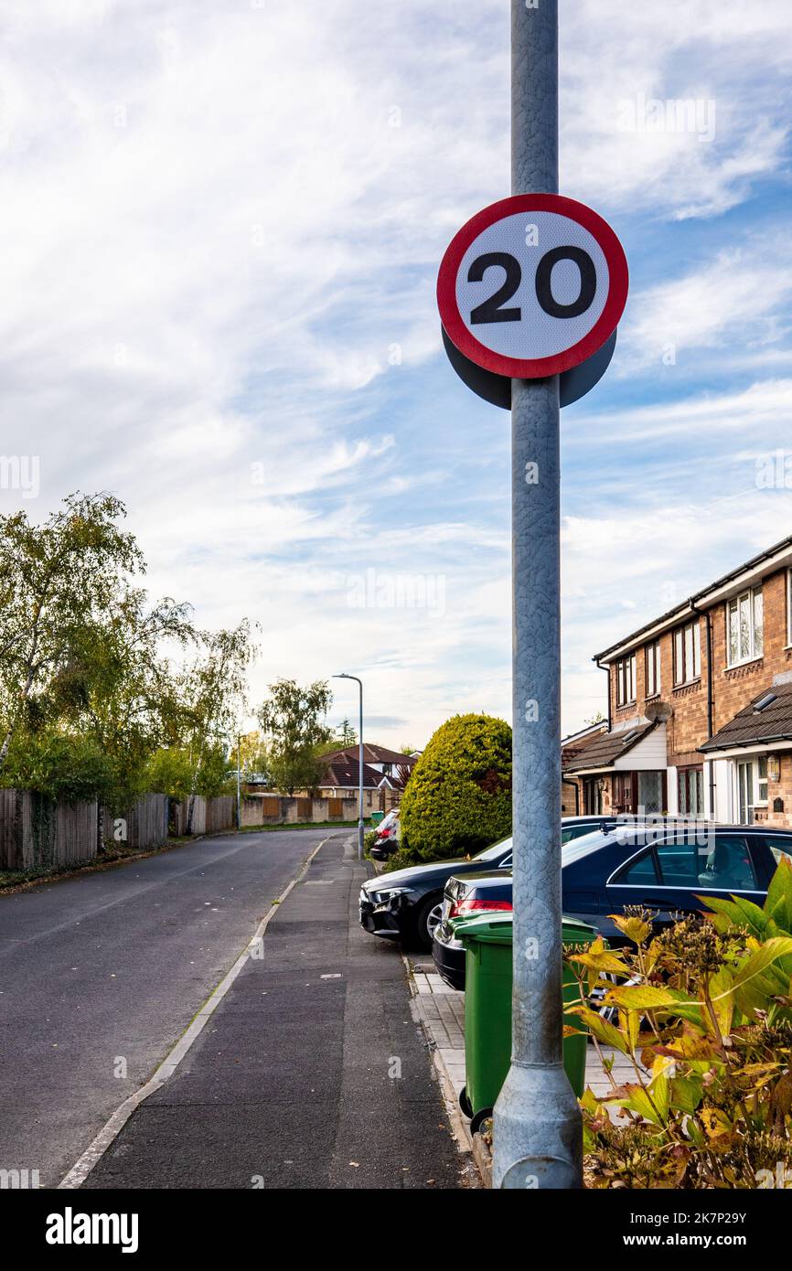 Vista detallada de un signo de límite de velocidad en carretera UK 20mph en una carretera bastante suburbana. Debido a la política del gobierno galés. Foto de stock