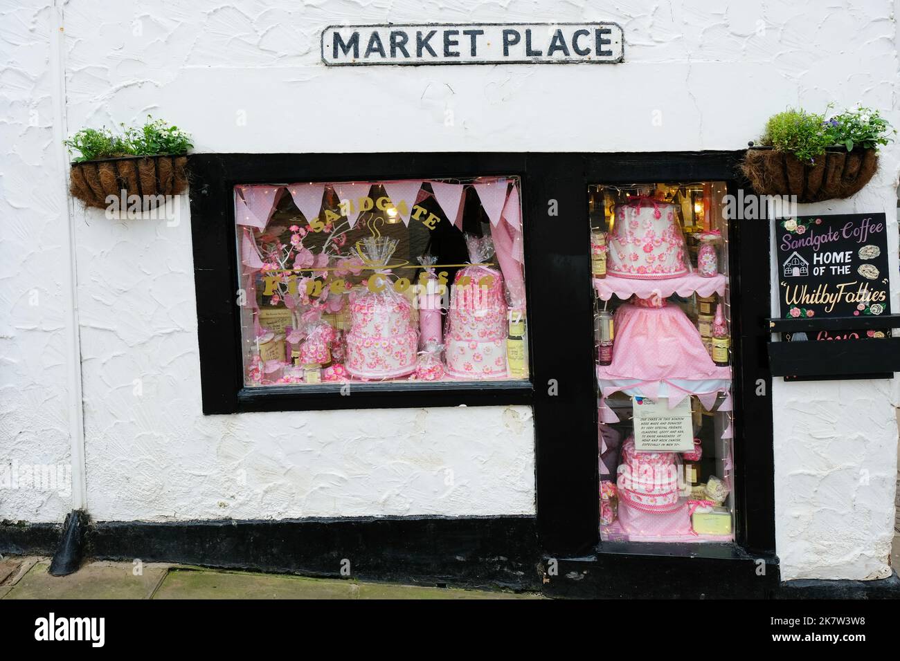 Una pequeña ventana que muestra pasteles, Whitby, Yorkshire, Reino Unido - John Gollop Foto de stock