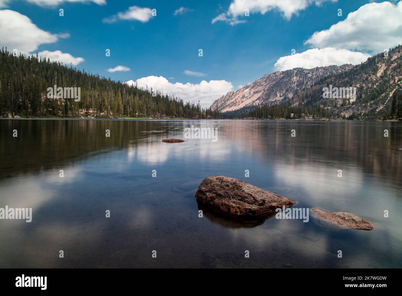 Imogene Lake, un gran lago alpino en las montañas Sawtooth de Idaho y dentro de Sawtooth Wilderness. Visto en un día de verano con cielos azules por encima. Foto de stock