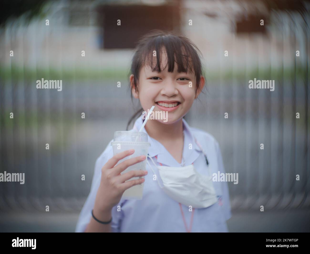 La estudiante sonrió y se rió alegremente después de beber agua y terminar la escuela por la noche Foto de stock