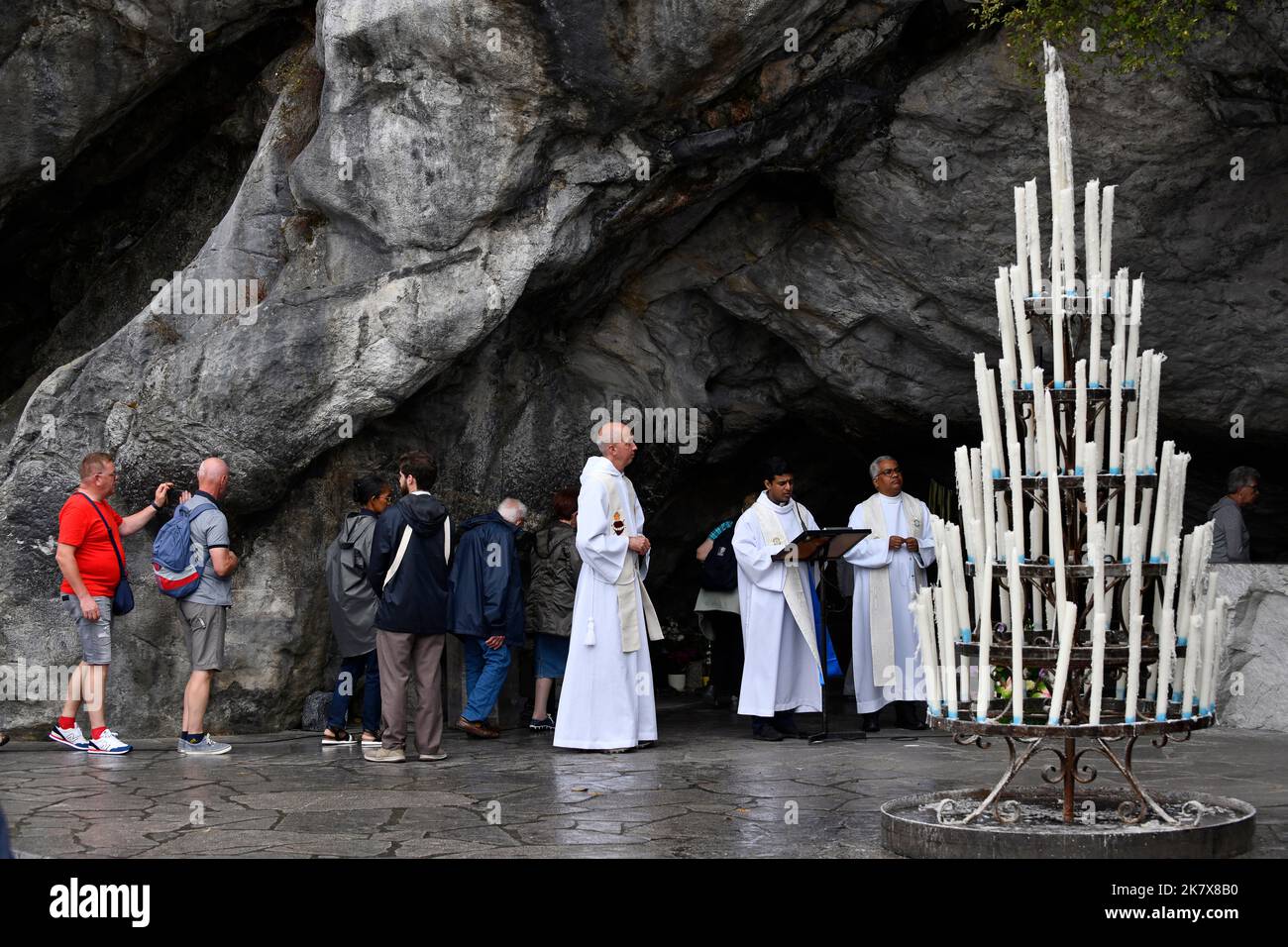 Lourdes, Hautes-Pyrénées, Francia. Sacerdotes que toman misa a la entrada de la Gruta de las Apariciones Foto de stock