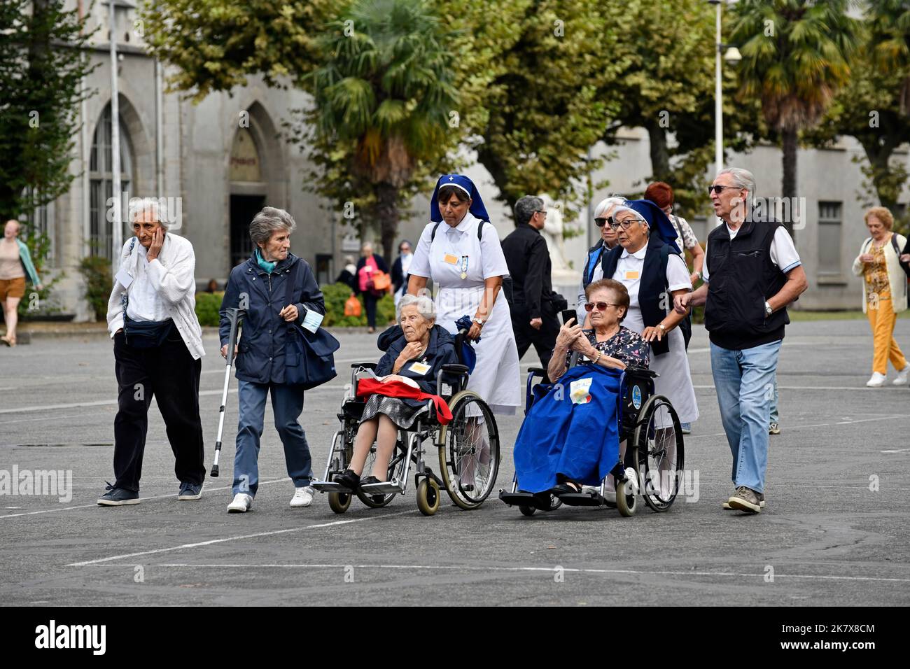 Lourdes, Hautes-Pyrénées, Francia. Cuidadores con peregrinos en sillas de ruedas Foto de stock