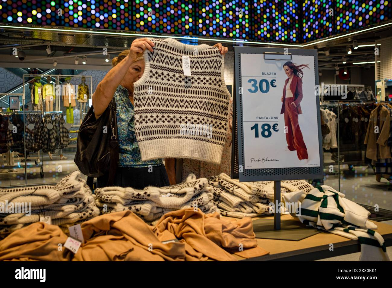 Barcelona, España. 15th de Oct de 2022. Una mujer se ve sosteniendo un  suéter de invierno dentro de una tienda de ropa Primark. Crédito: SOPA  Images Limited/Alamy Live News Fotografía de stock -