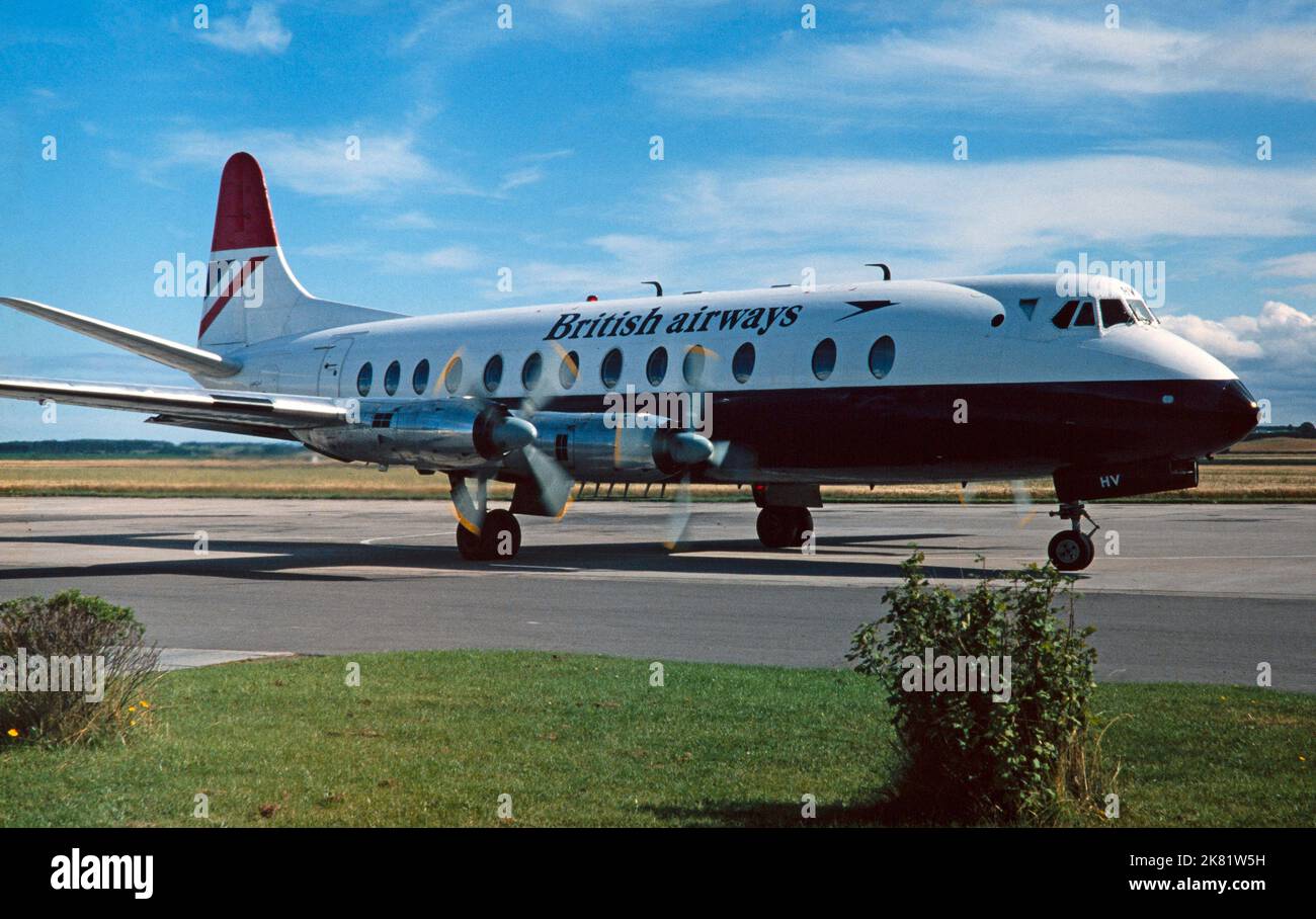Una fotografía en color de época que muestra un vizconde Vickers de British Airways, registro G-AOHV, taxi hacia un edificio de la terminal del aeropuerto en Inglaterra en la década de 1976. Foto de stock