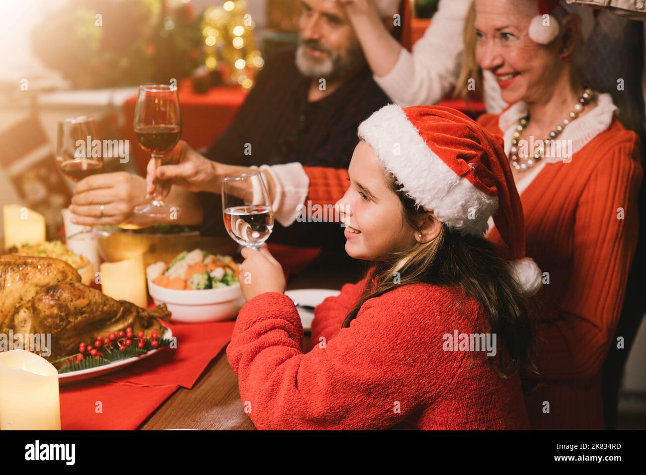 ¡Feliz Navidad! Una familia feliz está cenando en casa. Fiesta de celebración y compañerismo cerca del árbol Foto de stock