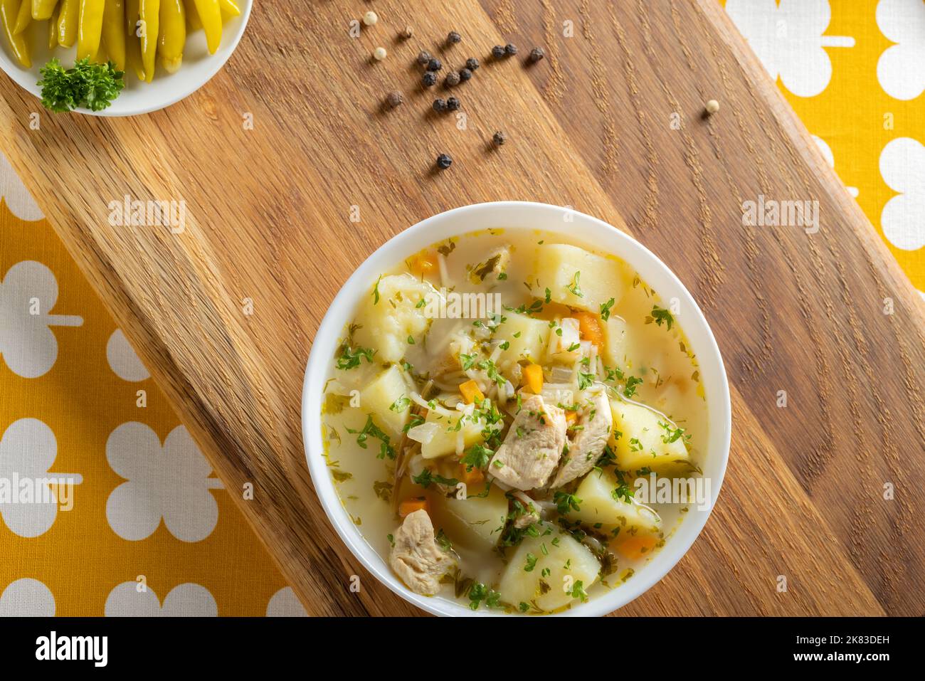 Sopa de pollo con patatas y fideos sobre una tabla de madera rústica - vista superior Foto de stock