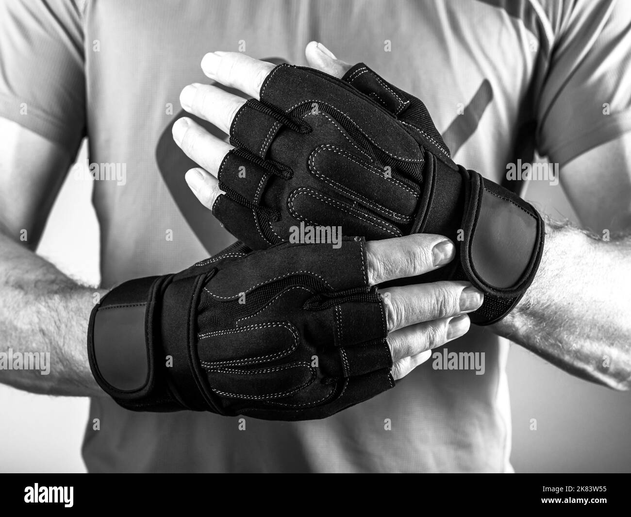 Fitness entrenamiento sin dedos guantes de cuero negro en manos del hombre  aislado sobre fondo blanco Fotografía de stock - Alamy