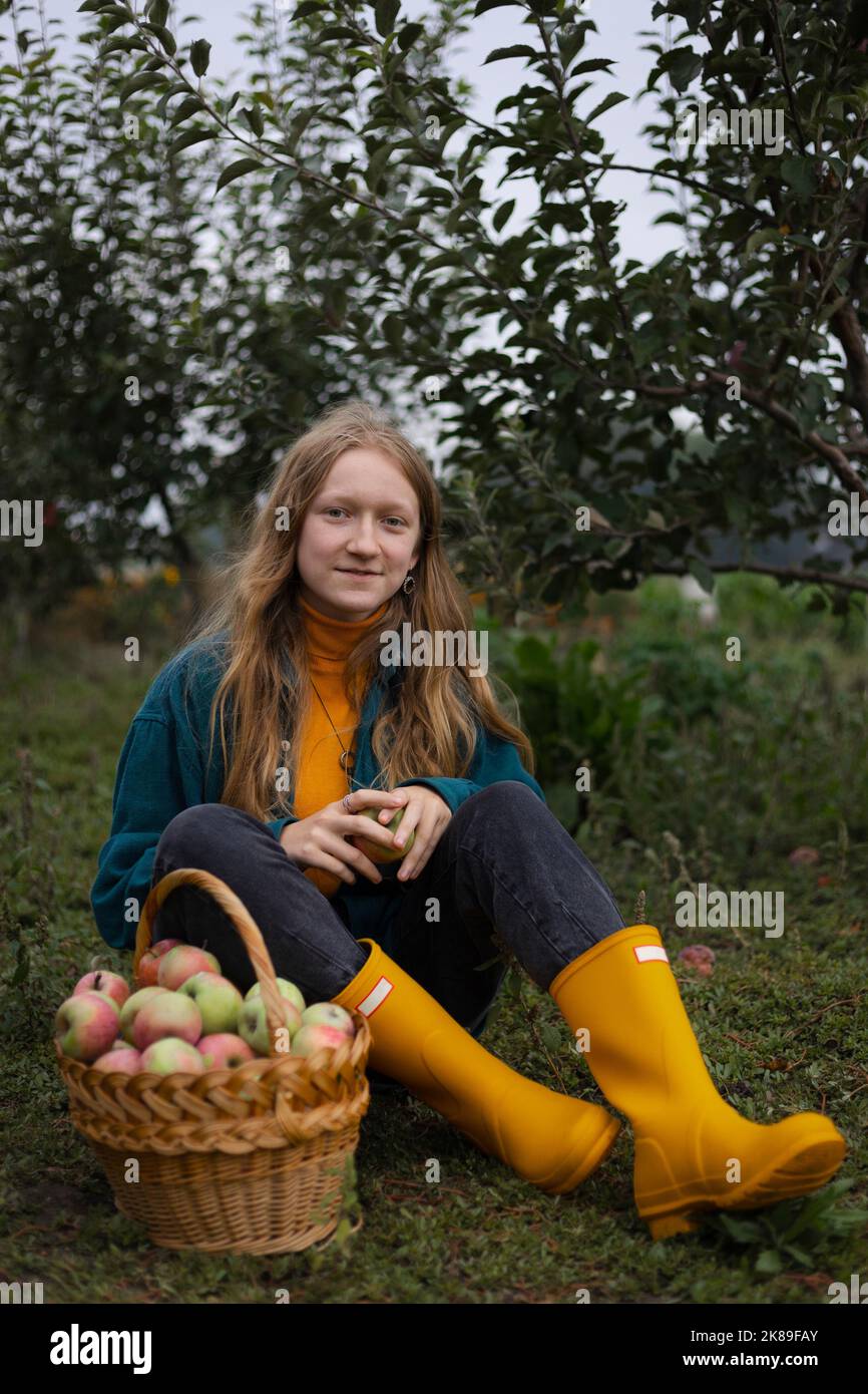 niña y cesta con jugosas manzanas en el jardín. estética de la vida rural Foto de stock