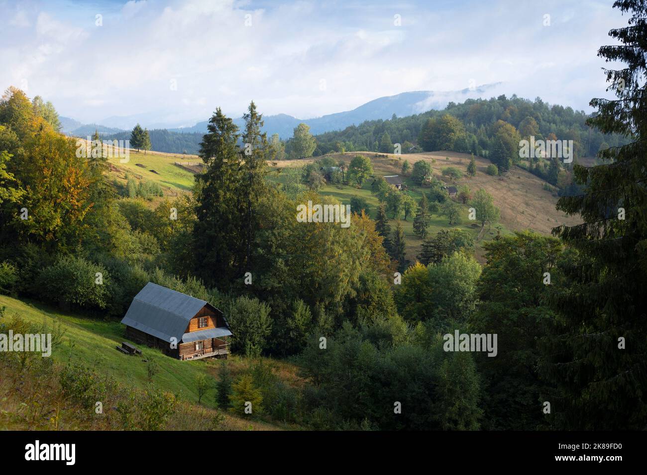 casa tradicional de madera con el telón de fondo de un paisaje de montaña. Cárpatos ucranianos Foto de stock