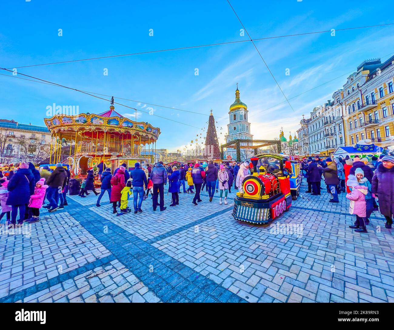 KIEV, UCRANIA - 2 DE ENERO de 2022: El tren turístico de colores, a caballo alrededor del árbol de Navidad en la Feria de Navidad, Sophia Square, el 2 de enero en Kiev, U Foto de stock